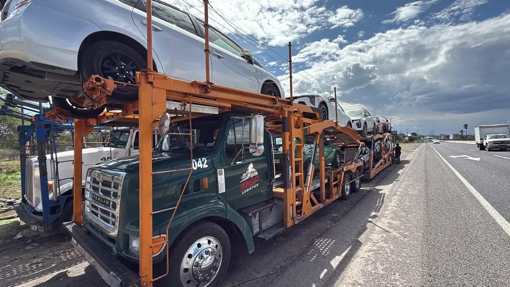 Tractocamión de RGP Logistics con vehículos cargados detenido a un costado de la carretera